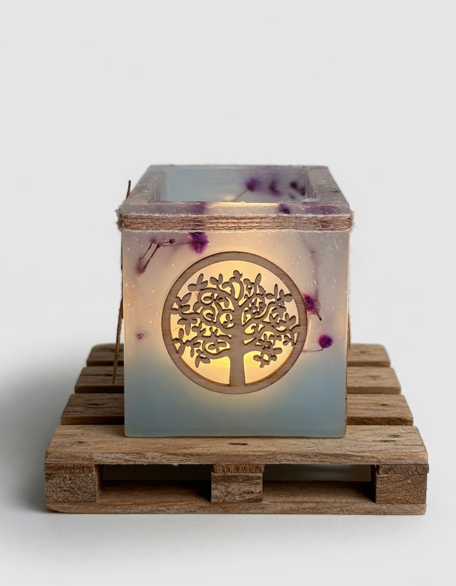 Vela hueca artesanal con símbolo del Árbol de la Vida en color azul], iluminada con luz LED cálida. Pieza única hecha a mano con flores naturales.